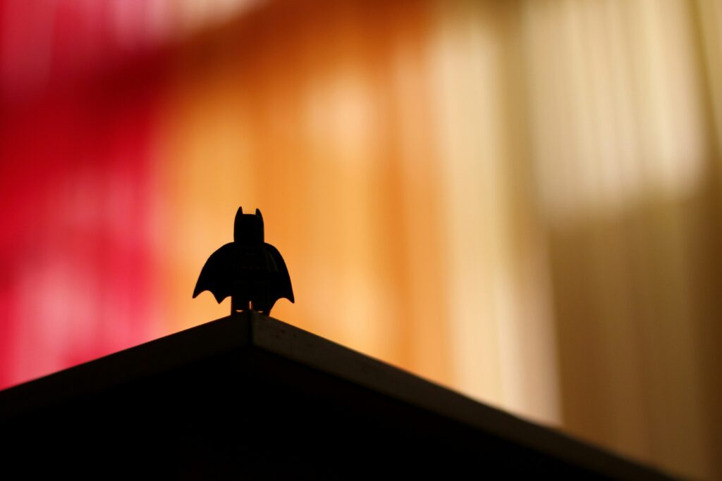 A shadowy figure with a cape standing on a peak.